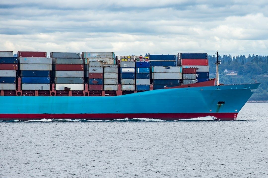Containerfartyg med färgglada containrar på väg genom en farled